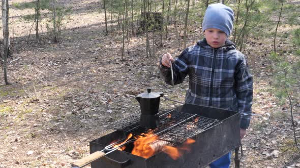 Boy Cooks Food on the Fire in the Grill. Country rest