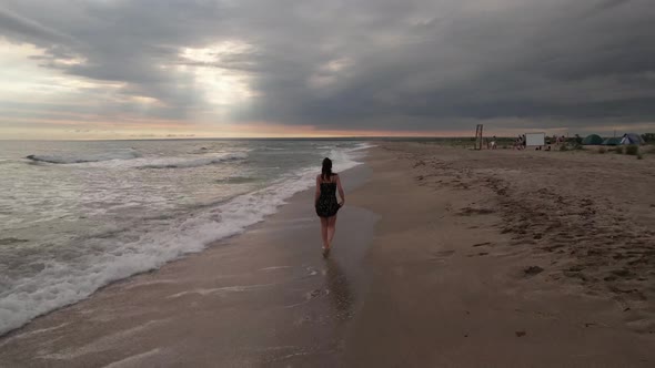 Girl Walking Along the Sea Coast