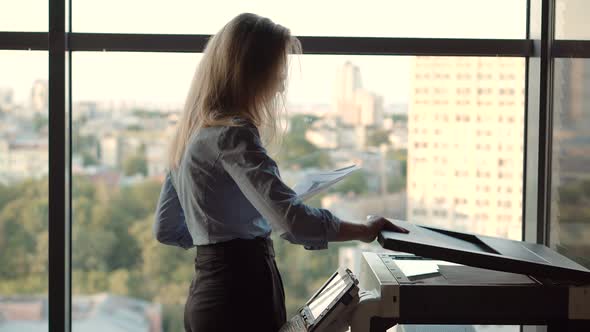 Businesswoman Using Printer In Office. Girl Using Copier For Replicate Paperwork. Printing Document. alt