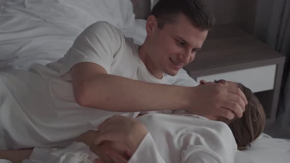 Newlyweds Kiss and Hug in Hotel Room alt