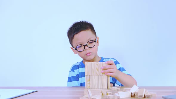 Asian boy playing with a wooden puzzle