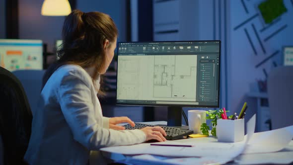 Woman Architect Matching Digital Plans From Pc with Blueprints alt