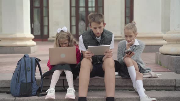 Camera Approaches To Children Using Devices and Looking at Camera. Portrait of Generation Z Boy and alt