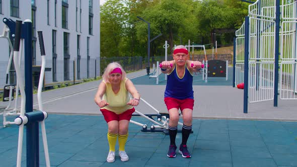 Senior Grandmother and Grandfather Sports Team Doing Squatting Fitness Exercising on Playground alt