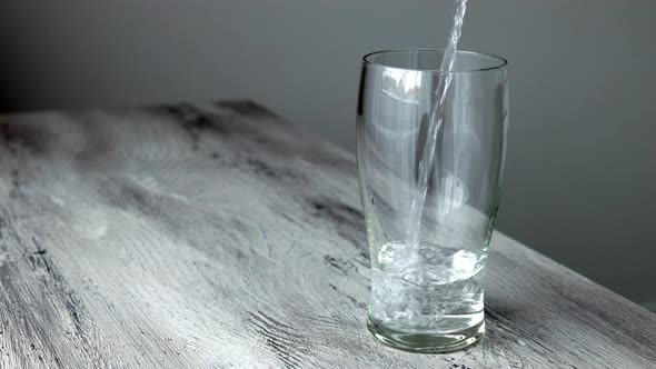 Pure Water Poured Into Glass Close Up in the Kitchen. Healthy lifestyle