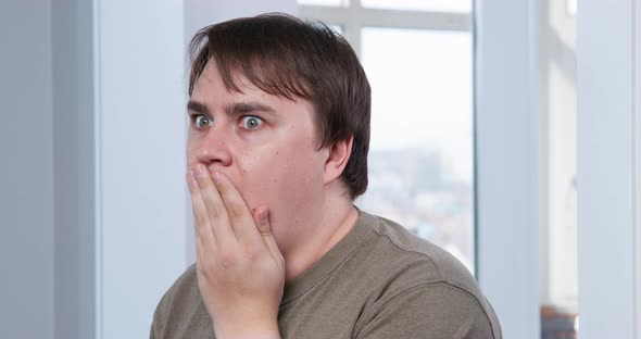 Young Man Saw Something Shocking and Stared in Surprise Covering His Mouth with Hand
