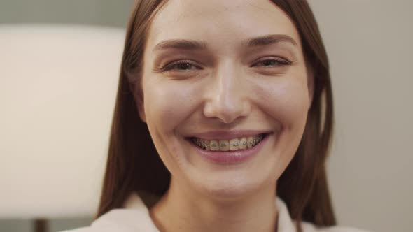 White Beautiful Woman with Braces Looks and Smiles at the Camera alt