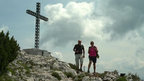 Active Happy Senior Couple on Hiking Tour at Summit Cross