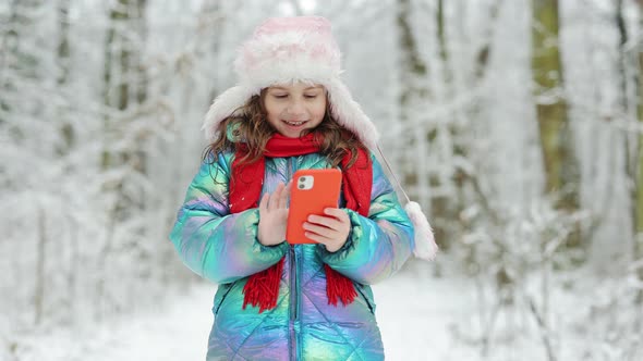 Little Kid Scrolling Funny Video in Smartphone Happy Child Playing at Winter Forest
