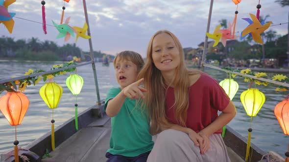 A Young Woman and Her Son Tourists Visit an Ancient Town of Hoi An in the Central Part of Vietnam alt