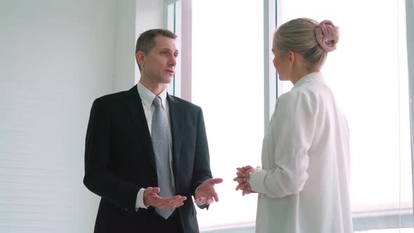 Two Business People Talk Project Strategy at Office alt