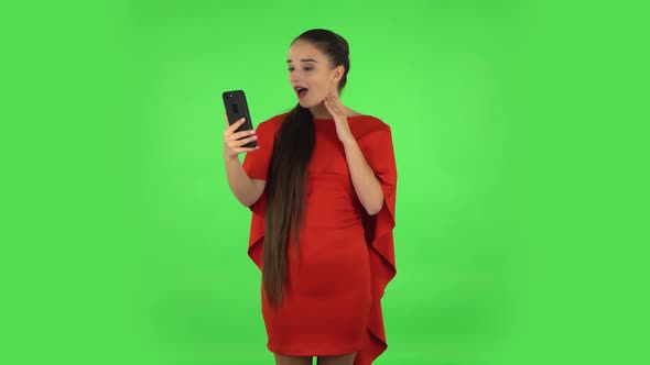 Pretty Young Woman Is Talking for Video Chat Using Mobile Phone and Rejoice. Green Screen alt