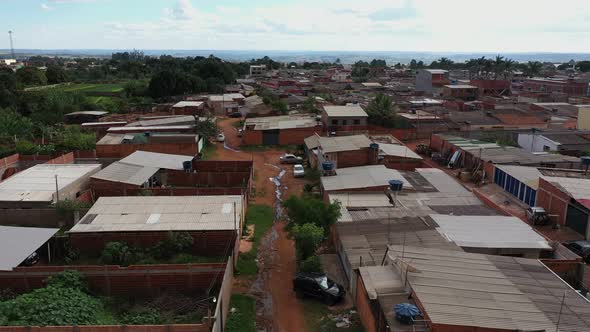 The dirt streets of the Sol Nascente favela with raw sewage in the streets - aerial view alt