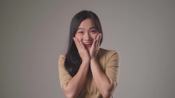 Confident asian woman happy standing smilling and looking at camera standing over background.