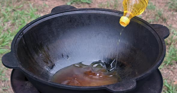 Cook Pours Oil Into the Cauldron a Before Cooking alt