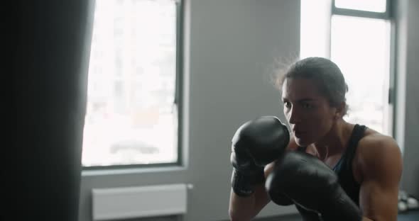 Woman Kickboxer in Boxing Gloves Punches Boxer Bag in Slow Motion Training in Boxing Club 60p Prores alt