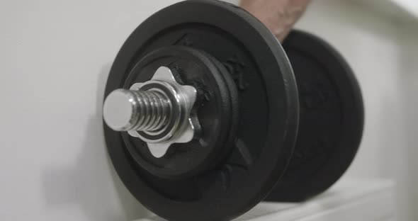 Man Puts a Dumbbell