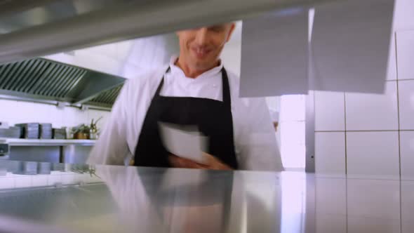 Group of chefs preparing and placing orders in the kitchen at hotel 4k alt