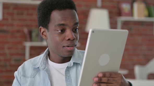 African Man Doing Video Chat on Tablet alt