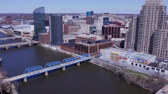 Bridges over still Grand River and Grand Rapids skyline, aerial pan alt