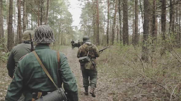 Re-enactors Dressed As German Wehrmacht Infantry Soldier In World War II Marching Walking Along alt