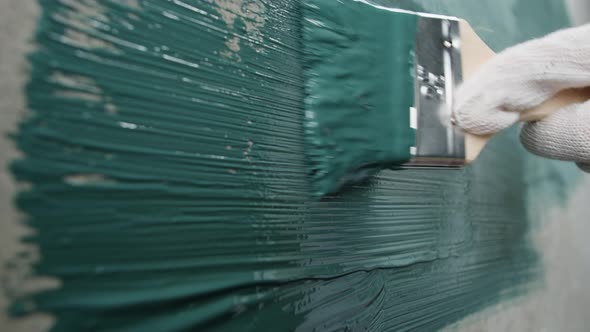Renovation Painting Walls with Blue Paint Using Brush Closeup alt