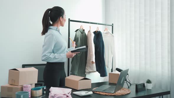 Young asian entrepreneurs check their clothes before selling them to customers.